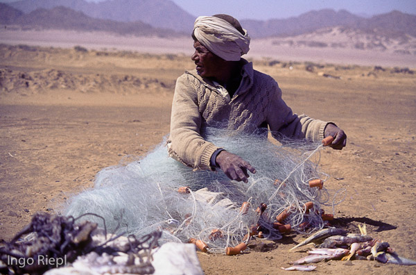 Bedouin fisherman repairing his net